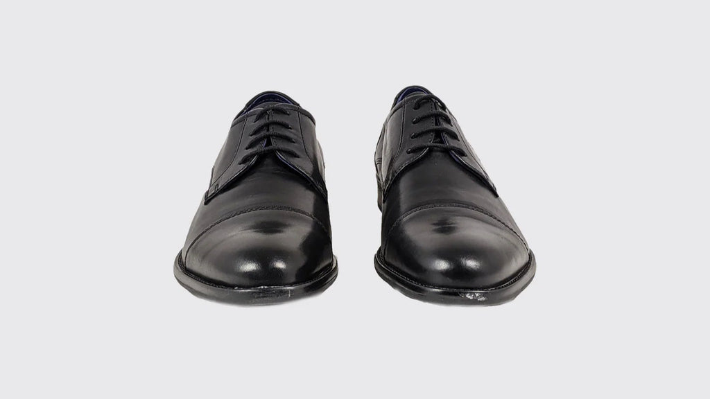 Pair of black dress shoes on a light gray background