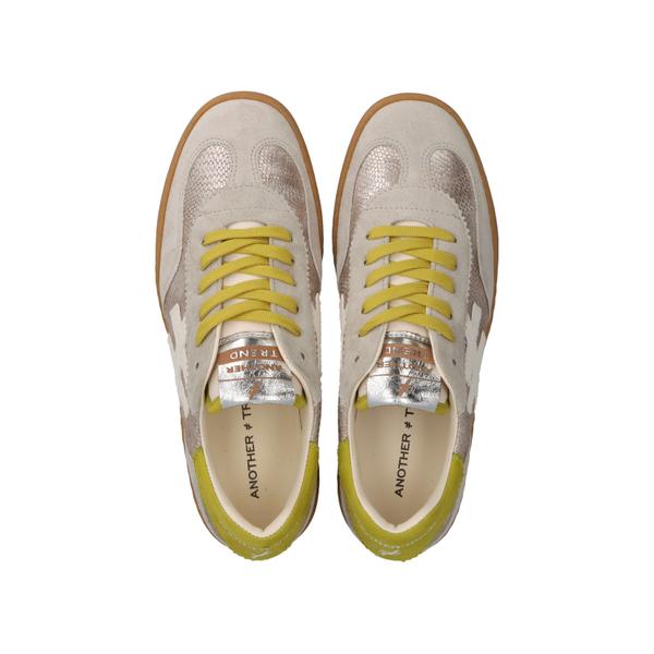 Pair of beige sneakers with yellow laces on a white background