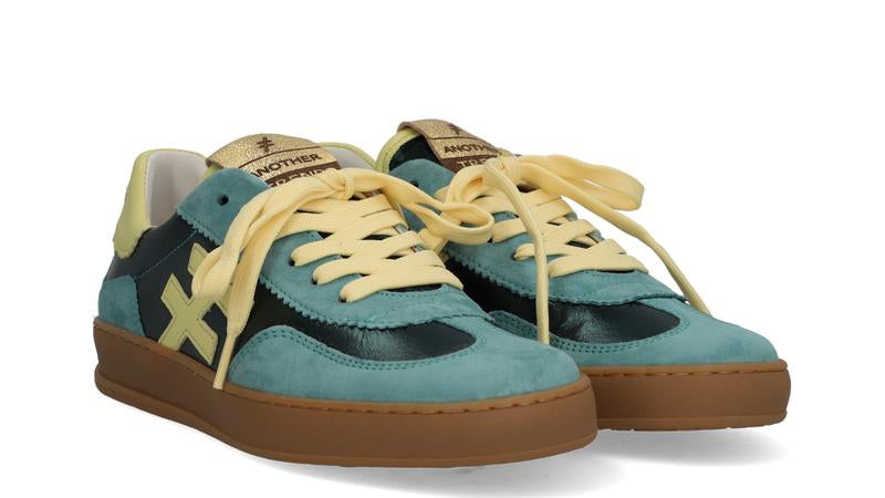 Pair of blue sneakers with yellow laces on a white background