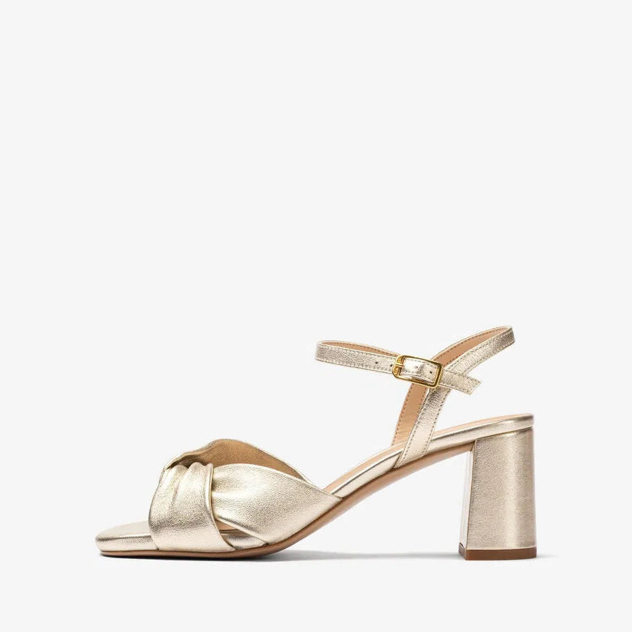 Gold high-heeled sandal on a white background