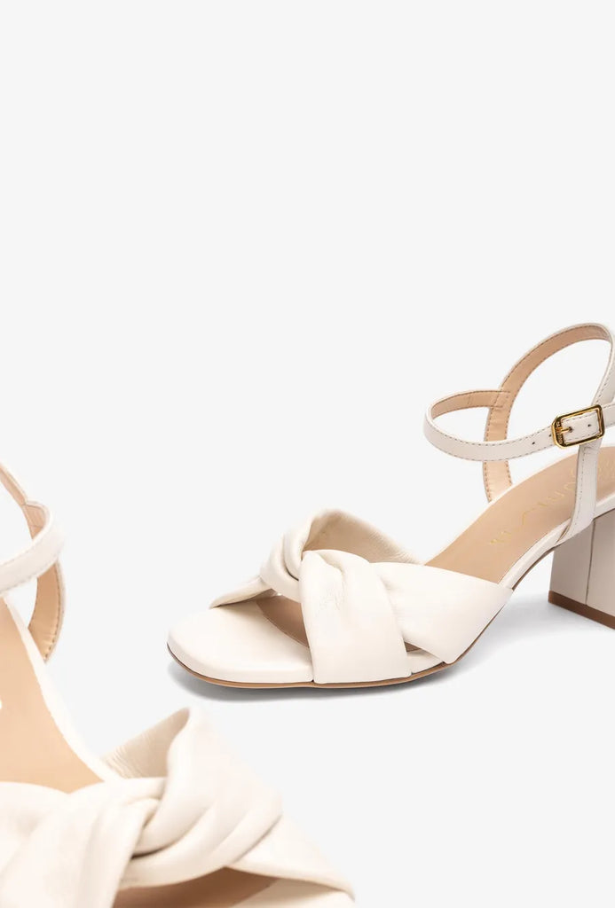 White sandal with a block heel on a white background