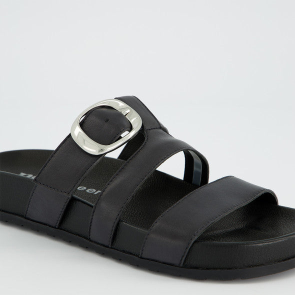 Black sandal with a silver buckle on a light gray background