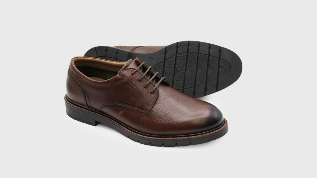 Brown leather shoes on a light gray background