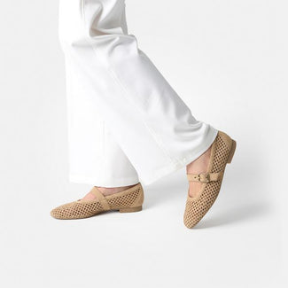 Beige flat shoe with a gold buckle on a white background