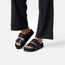 Load image into Gallery viewer, Black sandals worn with black pants on a white background
