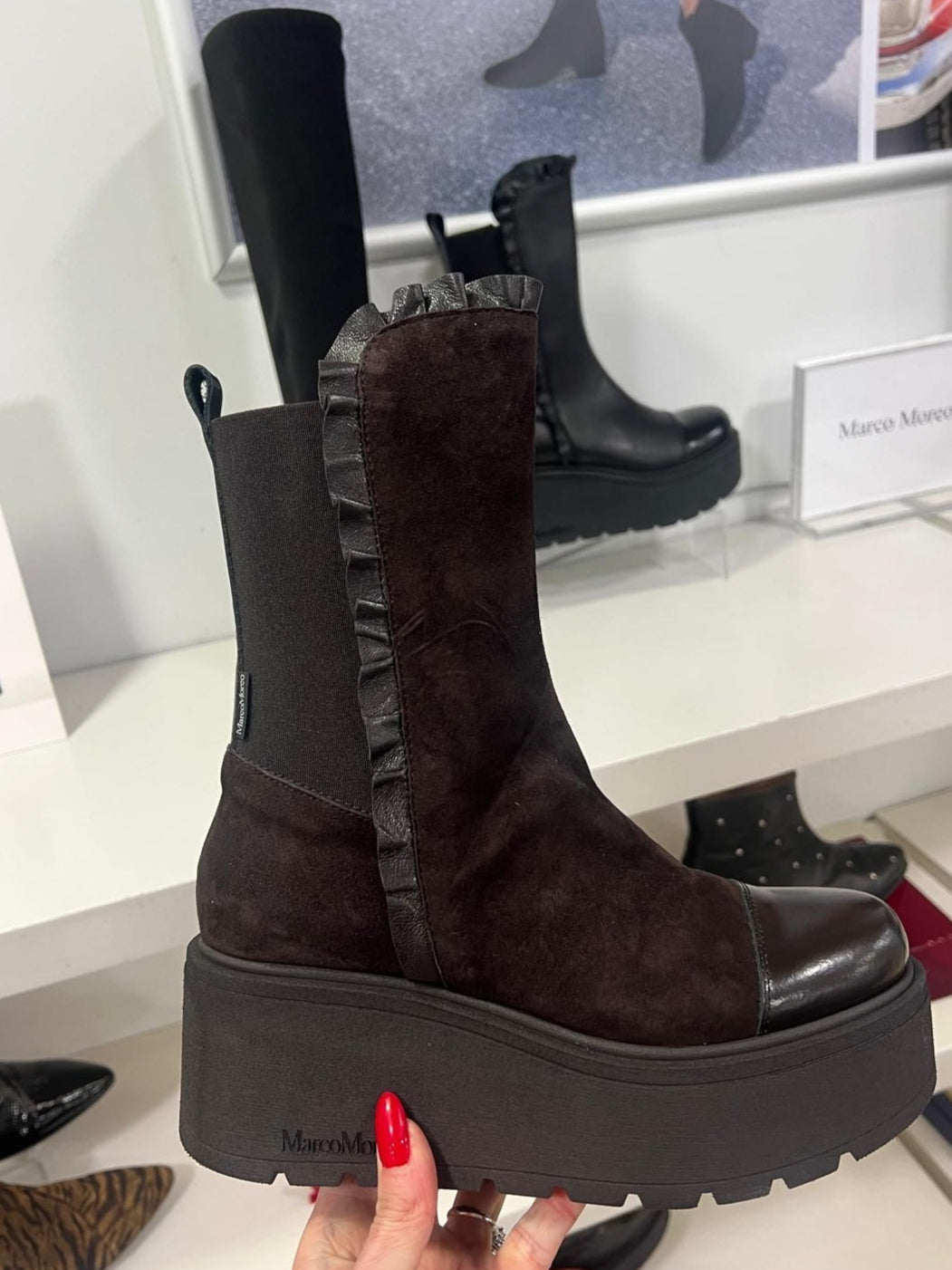 brown platform boot held up with a store display in the background
