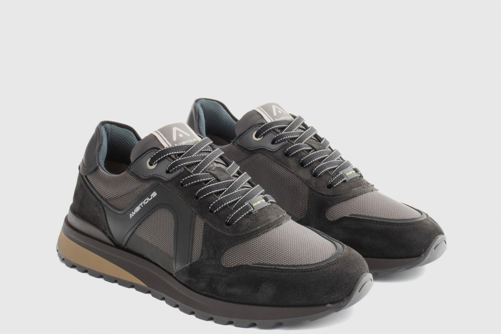 Pair of gray sneakers with a brand logo on a light gray background