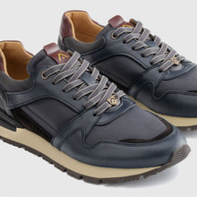 Load image into Gallery viewer, Pair of navy blue sneakers with brown accents on a light gray background
