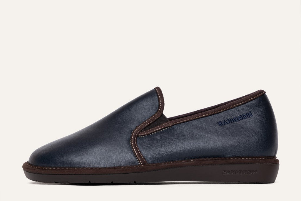 Navy slip-on shoe with brown accents on a white background
